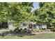 Charming single-story home with mature trees, green shutters, and landscaped front yard at 835 Pearleman Teague Rd, Siler City, NC 27344