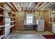 Interior shot of the garage showing exposed beams, open shelving, a window and a refrigerator at 835 Pearleman Teague Rd, Siler City, NC 27344