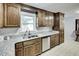 View of the kitchen showcasing wood cabinets, a stainless dishwasher and granite countertops at 835 Pearleman Teague Rd, Siler City, NC 27344