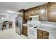 Well-lit kitchen with wood cabinets, white appliances, and granite countertops at 835 Pearleman Teague Rd, Siler City, NC 27344