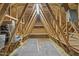 View of the unfinished attic space featuring exposed wood beams, insulation, and carpeted floor at 853 Bluffcreek Dr, Fuquay Varina, NC 27526