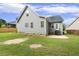 Exterior back of house, featuring gray siding, multiple windows, patio, and healthy lawn at 853 Bluffcreek Dr, Fuquay Varina, NC 27526