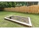 Landscaped backyard with a garden bed, healthy lawn, and a full wood fence at 853 Bluffcreek Dr, Fuquay Varina, NC 27526
