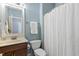 Cozy bathroom boasts a sink with a wooden vanity, commode, and shower at 853 Bluffcreek Dr, Fuquay Varina, NC 27526