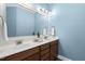 Bathroom featuring double sinks, dark brown cabinets and a large mirror at 853 Bluffcreek Dr, Fuquay Varina, NC 27526