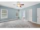 Carpeted bedroom with blue walls, ceiling fan and access to ensuite bathroom at 853 Bluffcreek Dr, Fuquay Varina, NC 27526