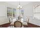 Bright dining room features wainscoting, a glass table, and large windows for abundant natural light at 853 Bluffcreek Dr, Fuquay Varina, NC 27526