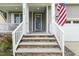 Inviting entryway with stone steps, white railings, and a glimpse of the home's well-lit interior at 853 Bluffcreek Dr, Fuquay Varina, NC 27526