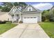 Inviting gray home with a well-kept lawn, covered porch, and convenient two-car garage, perfect for Gathering living at 853 Bluffcreek Dr, Fuquay Varina, NC 27526