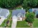Charming white home with grey roof and a spacious lawn, perfectly nestled among trees and lush green landscapes at 8841 Deerland Grove Dr, Raleigh, NC 27615