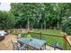 Back deck with dining and lounge seating overlooking the lawn and mature trees at 8841 Deerland Grove Dr, Raleigh, NC 27615