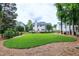 Expansive backyard featuring lush green lawn, mature trees, and a wooden deck for outdoor enjoyment at 8841 Deerland Grove Dr, Raleigh, NC 27615