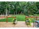 Spacious backyard with a deck, large lawn area, flower planters, mature trees and landscaping at 8841 Deerland Grove Dr, Raleigh, NC 27615