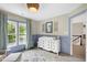 Stylish Bedroom featuring a changing table, window with drapes, and a unique light fixture at 8841 Deerland Grove Dr, Raleigh, NC 27615