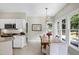 A sunlit dining area features a table with seating under modern lighting with views of the backyard at 8841 Deerland Grove Dr, Raleigh, NC 27615