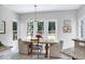 Bright dining room features a wood table, neutral chairs, and windows overlooking the backyard at 8841 Deerland Grove Dr, Raleigh, NC 27615