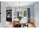Classic dining room with patterned wallpaper, chandelier, and a view of the front door at 8841 Deerland Grove Dr, Raleigh, NC 27615