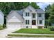 Charming two-story traditional home with a well-manicured lawn, attached garage, and welcoming front entrance at 8841 Deerland Grove Dr, Raleigh, NC 27615