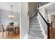 Elegant foyer with a carpeted staircase next to a dining room with wallpaper at 8841 Deerland Grove Dr, Raleigh, NC 27615