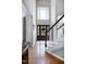 Sunlit foyer with hardwood floors, staircase, and a glass-paneled front door at 8841 Deerland Grove Dr, Raleigh, NC 27615