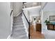 Bright foyer featuring hardwood floors, carpeted staircase, and an elegant railing at 8841 Deerland Grove Dr, Raleigh, NC 27615