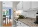 Bright kitchen with granite countertops and white cabinetry, next to dining area with blue accents at 8841 Deerland Grove Dr, Raleigh, NC 27615