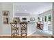 The kitchen island with bar stool seating overlooks the adjacent breakfast and kitchen with recessed lighting at 8841 Deerland Grove Dr, Raleigh, NC 27615