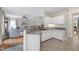A modern kitchen featuring white cabinets and granite countertops opens up into the living room and dining room at 8841 Deerland Grove Dr, Raleigh, NC 27615