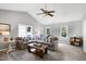 Bright living room featuring vaulted ceilings, neutral paint, windows, and a large sectional sofa at 8841 Deerland Grove Dr, Raleigh, NC 27615