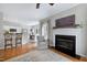 Bright living room features a fireplace, an area rug, and an open floor plan to the kitchen and dining area at 8841 Deerland Grove Dr, Raleigh, NC 27615