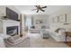 Inviting living room with a white sectional sofa, fireplace and a decorative area rug under a ceiling fan at 8841 Deerland Grove Dr, Raleigh, NC 27615