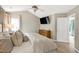 Well-lit main bedroom with ceiling fan, a dresser and view of another bedroom at 8841 Deerland Grove Dr, Raleigh, NC 27615
