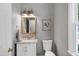 Charming powder room has a granite sink, ornate mirror, and sconce lighting at 8841 Deerland Grove Dr, Raleigh, NC 27615