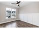 Bright bedroom with large window, ceiling fan, beautiful wood floors, and white wainscoting at 9 Moss Side Ter, Durham, NC 27703