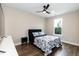 Cozy bedroom with ceiling fan, dark wood floors, a modern bed frame and a black nightstand at 9 Moss Side Ter, Durham, NC 27703