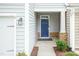 Welcoming front entryway with a blue door, stone accents, and modern lighting fixture at 9 Moss Side Ter, Durham, NC 27703