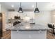 Modern kitchen features white cabinetry, stainless steel appliances, and an island with a granite countertop at 9 Moss Side Ter, Durham, NC 27703