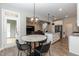 Open-concept kitchen with island, adjacent breakfast nook, and view into the living room at 9 Moss Side Ter, Durham, NC 27703