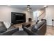 Comfortable living room with a large TV, leather furniture, and access to staircase at 9 Moss Side Ter, Durham, NC 27703