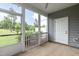 A screened in back porch with a view of the green space backyard, with a door and windows at 9 Moss Side Ter, Durham, NC 27703