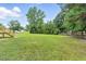 A large grassy backyard with mature trees and an abundance of room to play and entertain at 107 Winter Ct, Selma, NC 27576