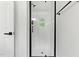 Modern bathroom featuring a bright shower with glass door, window, and dark hardware at 107 Winter Ct, Selma, NC 27576