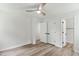Bedroom with neutral walls, a ceiling fan, wood floors, and a closet with a view of the house at 107 Winter Ct, Selma, NC 27576
