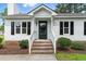 Inviting front porch with brick steps, white railings, and a black front door, blending classic charm with modern appeal at 107 Winter Ct, Selma, NC 27576
