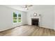 Bright living room features wood floors, a classic fireplace, and a modern ceiling fan for a welcoming space at 107 Winter Ct, Selma, NC 27576