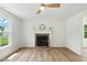 Bright living room features wood floors, a classic fireplace, and a modern ceiling fan for a welcoming space at 107 Winter Ct, Selma, NC 27576