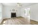 Bright living room features wood floors, a classic fireplace, and a modern ceiling fan for a welcoming space at 107 Winter Ct, Selma, NC 27576