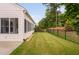 Spacious backyard featuring a black fence, lush green grass, and mature trees for added privacy at 1104 Gaston Manor Dr, Durham, NC 27703