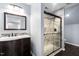 Updated bathroom with dark wood vanity, framed mirror, and a modern tiled shower with glass doors at 1104 Gaston Manor Dr, Durham, NC 27703