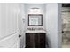 Modern bathroom with dark wood vanity, updated lighting, framed mirror, and tile accent wall at 1104 Gaston Manor Dr, Durham, NC 27703